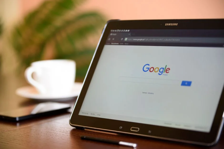A modern workspace showing hands analyzing marketing data on a laptop and paper documents.